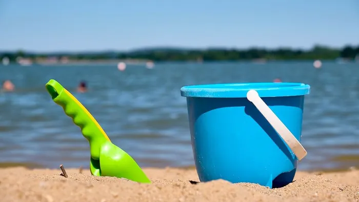 Sand bucket and spade on a lakeside beach
