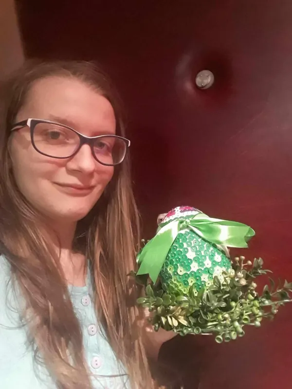 Anna holding a green decorated Easter egg