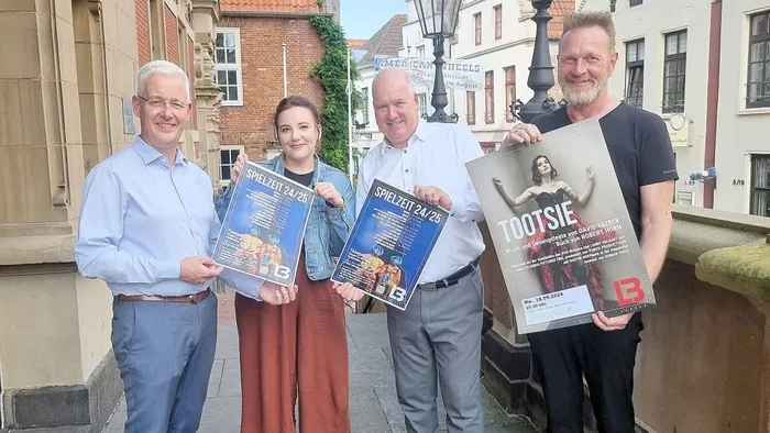 Four people presenting posters for the Landesbühne Nord’s new season in Leer