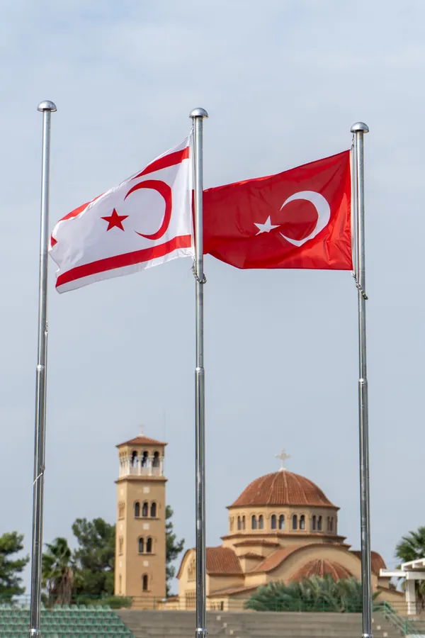 The flags of Northern Cyprus and Turkey in front of a church